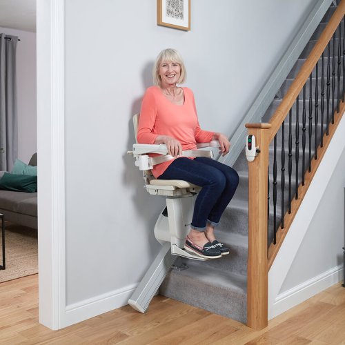 Woman going up stairs on straight stairlift - 1100 model